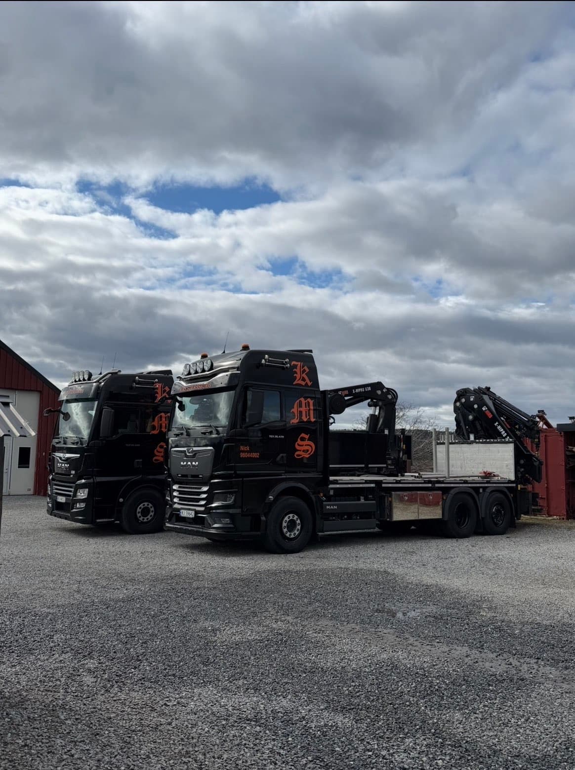 To svarte KMS-kranbiler med HIAB-kranpark på verkstedtomt i Vestfossen